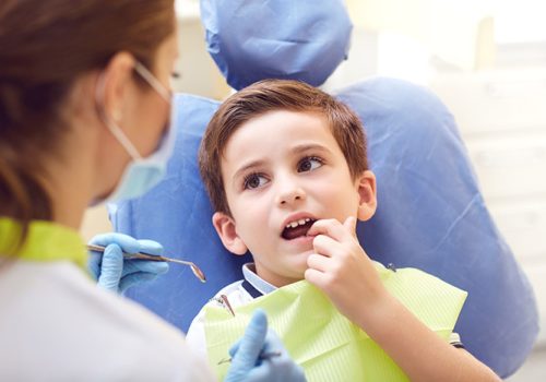 A child with a dentist in a dental office. Dental treatment in a children's clinic.